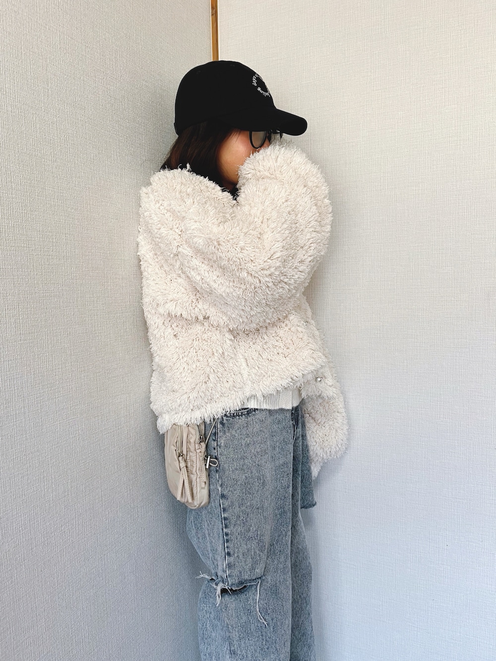 ホワイト系のニット/セーター、ホワイト系のジャケット/アウター、ブルー系のデニムパンツを着用したキッズの冬コーディネートの5枚目の写真