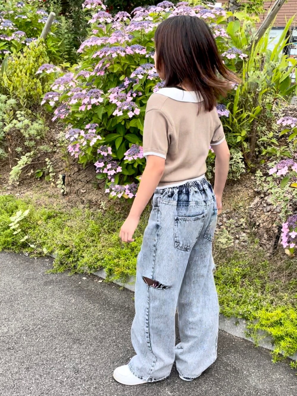 ベージュ系のトップス、ブルー系のデニムパンツ、ブラック系のサンダルを着用したキッズの夏コーディネートの4枚目の写真