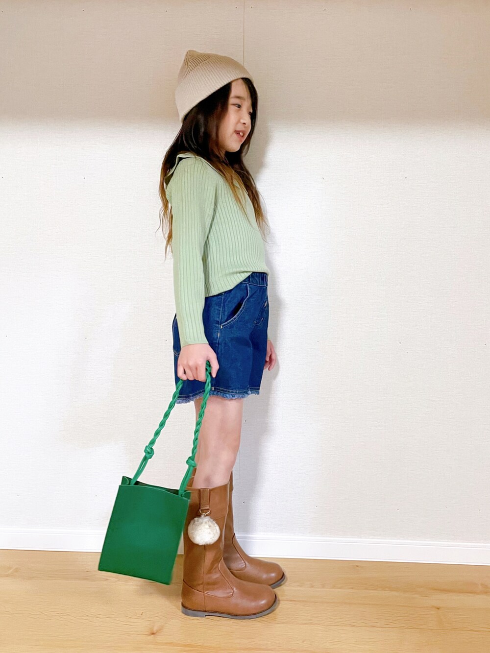 グリーン系のニット/セーター、ブルー系のその他パンツ、イエロー系のブーツを着用したキッズの冬コーディネートの2枚目の写真