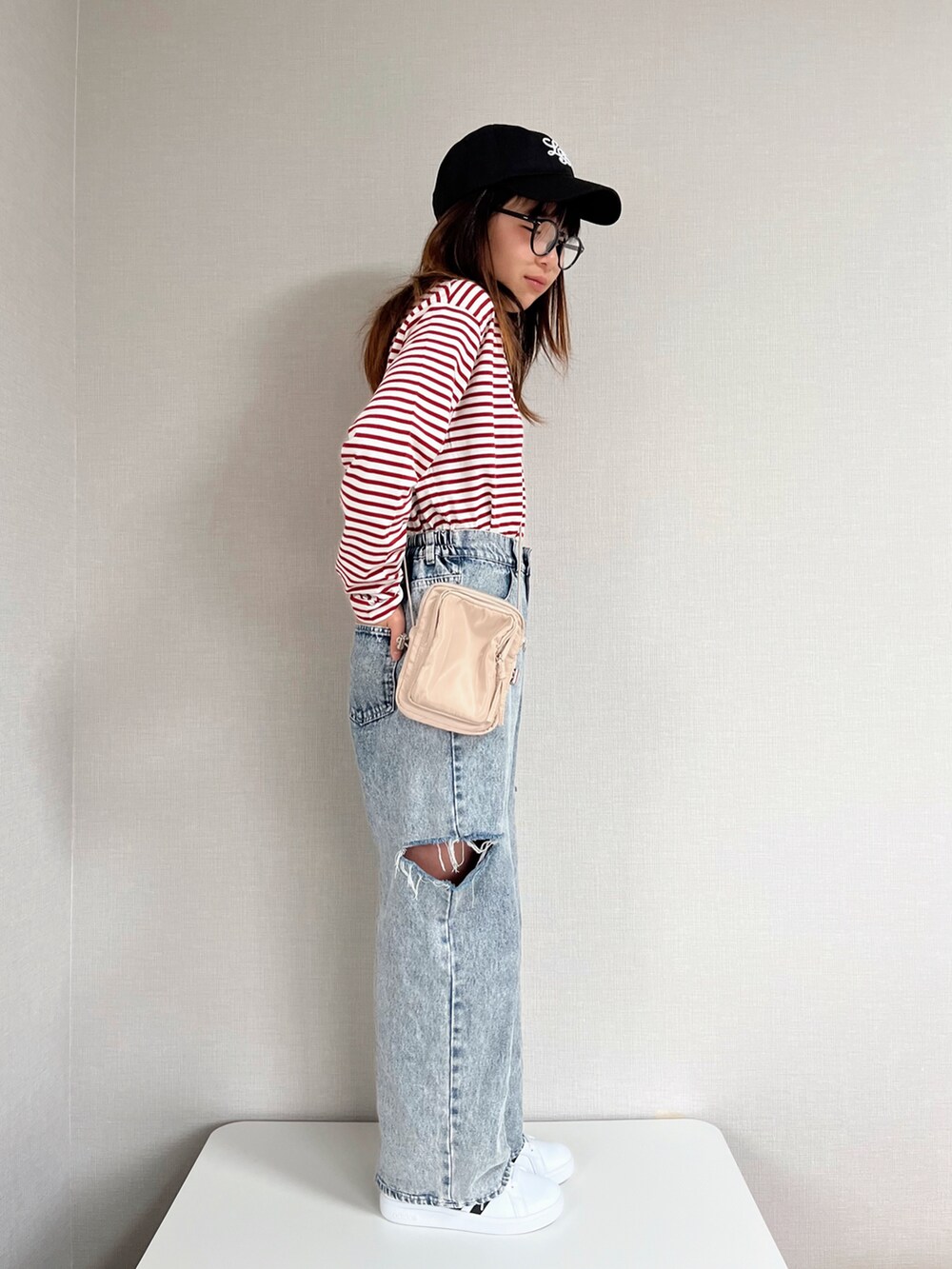 レッド系のTシャツ/カットソー、ブルー系のデニムパンツ、ベージュ系のショルダーバッグを着用したキッズの冬コーディネートの2枚目の写真