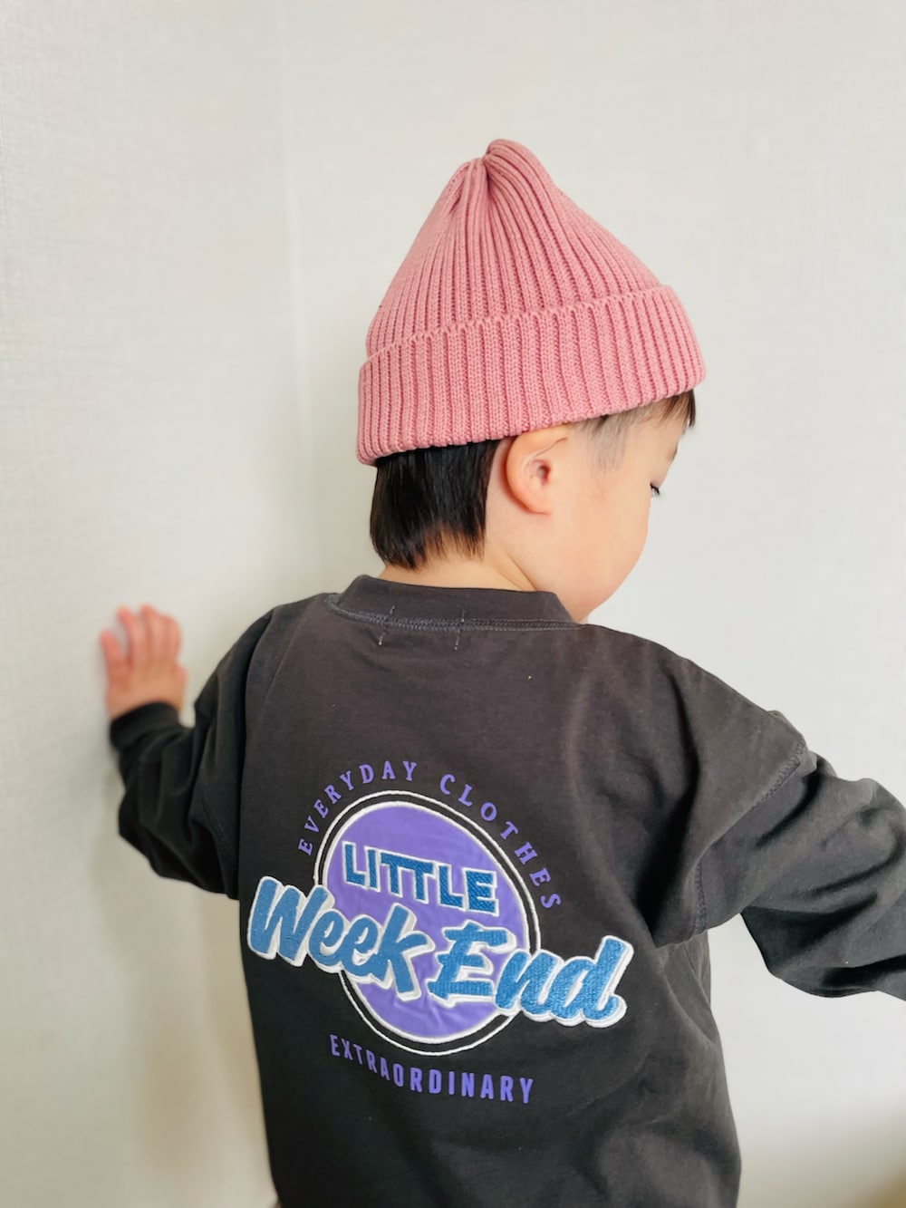 グレー系のトップス、ブルー系のパンツ、ブラック系のサンダルを着用したキッズの春コーディネートの2枚目の写真