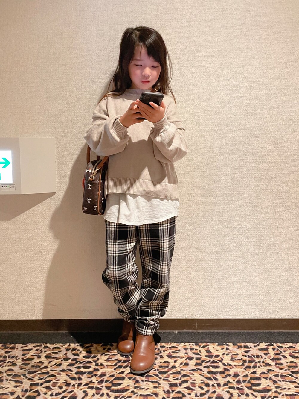 「冬コーデ、あったかコーデ、チェック、チェックパンツ、ブーツ、レイヤードスタイル、ニット、スヌーピー、ダウンジャケット、GLOBAL WORK、カジュアルコーデ、キャリーバッグ、トリコロール」｜「UNIQLOのアイテム（ジャケット/アウター、ホワイト系）」を使った、naaaさん（キッズ・130cm）の冬コーディネートの3枚目の写真