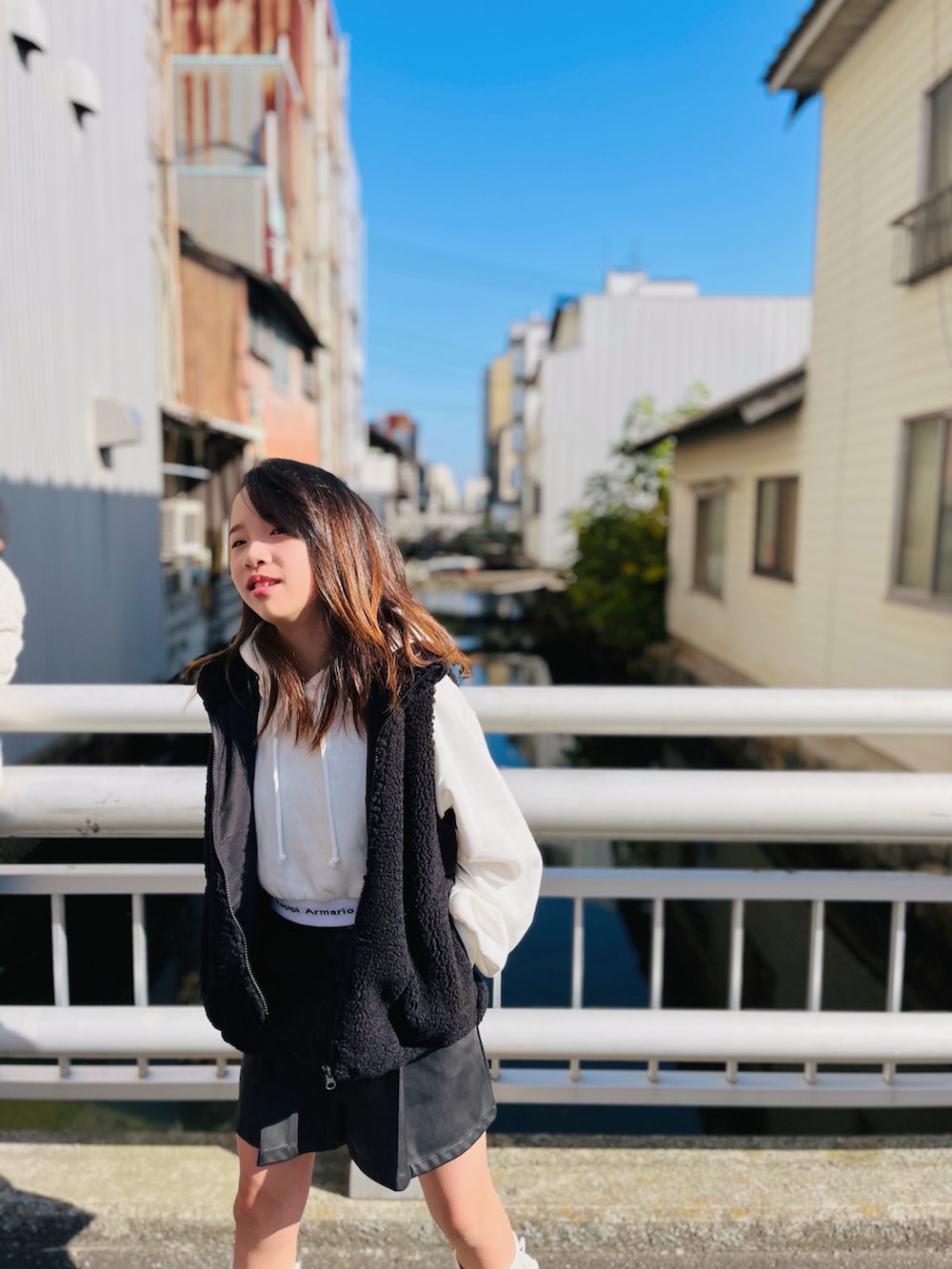 ブラック系のベスト、ホワイト系のパーカー、ブラック系のパンツを着用したキッズの秋コーディネートの4枚目の写真