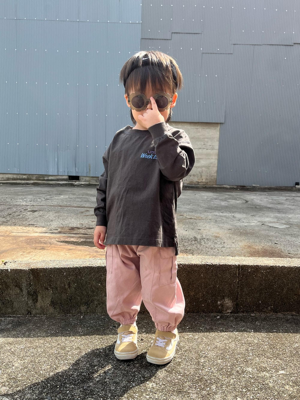 グレー系のトップス、ピンク系のカーゴパンツ、ブラック系のヘアバンドを着用したキッズの秋コーディネートの2枚目の写真