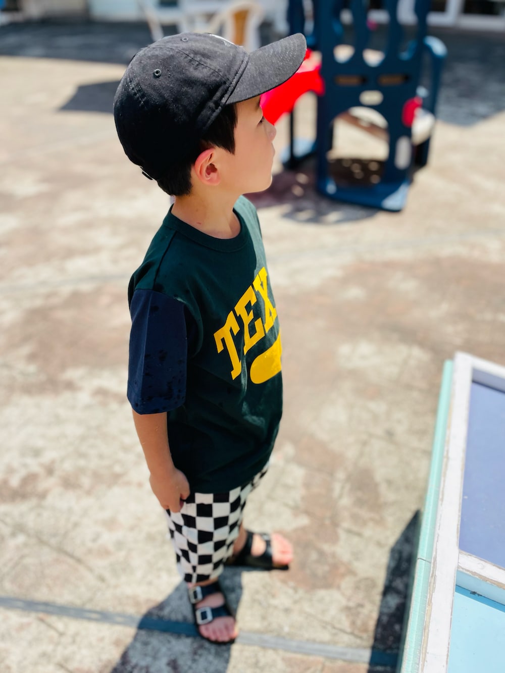 グリーン系のTシャツ/カットソー、ブラック系のサンダル、ブラック系のその他パンツを着用したキッズの夏コーディネートの2枚目の写真
