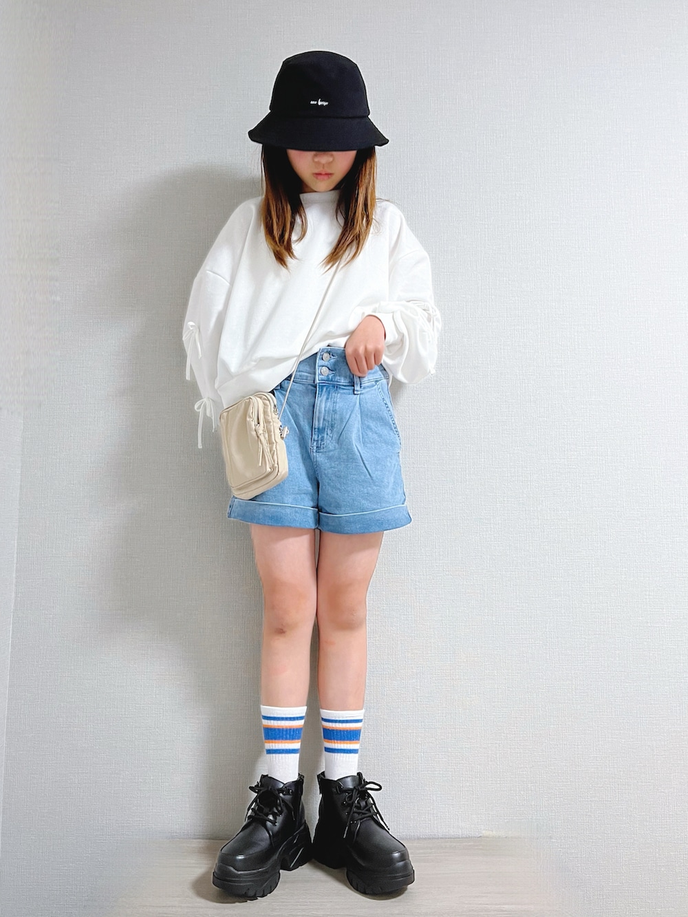 ブルー系のデニムパンツ、ホワイト系のトップス、ブラック系のブーツを着用したキッズの春コーディネートの2枚目の写真