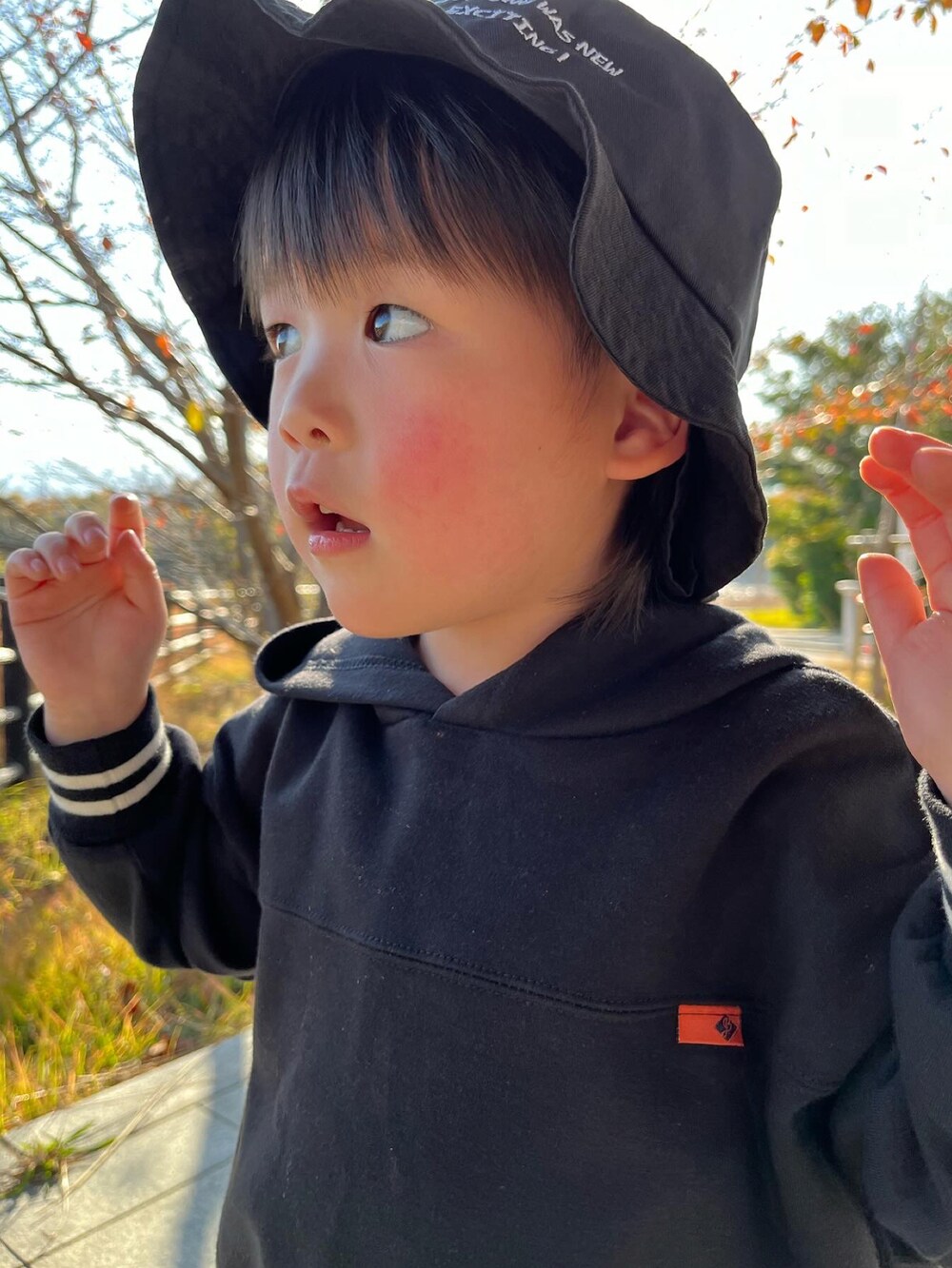 ブラック系のパーカー、ブルー系のデニムパンツ、ベージュ系のスニーカーを着用したキッズの冬コーディネートの4枚目の写真