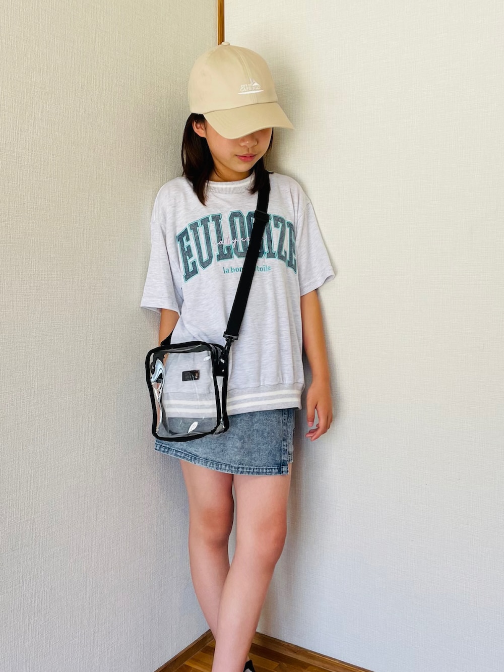 ブラック系のスニーカー、ホワイト系のトップス、ベージュ系のキャップを着用したキッズの夏コーディネートの2枚目の写真