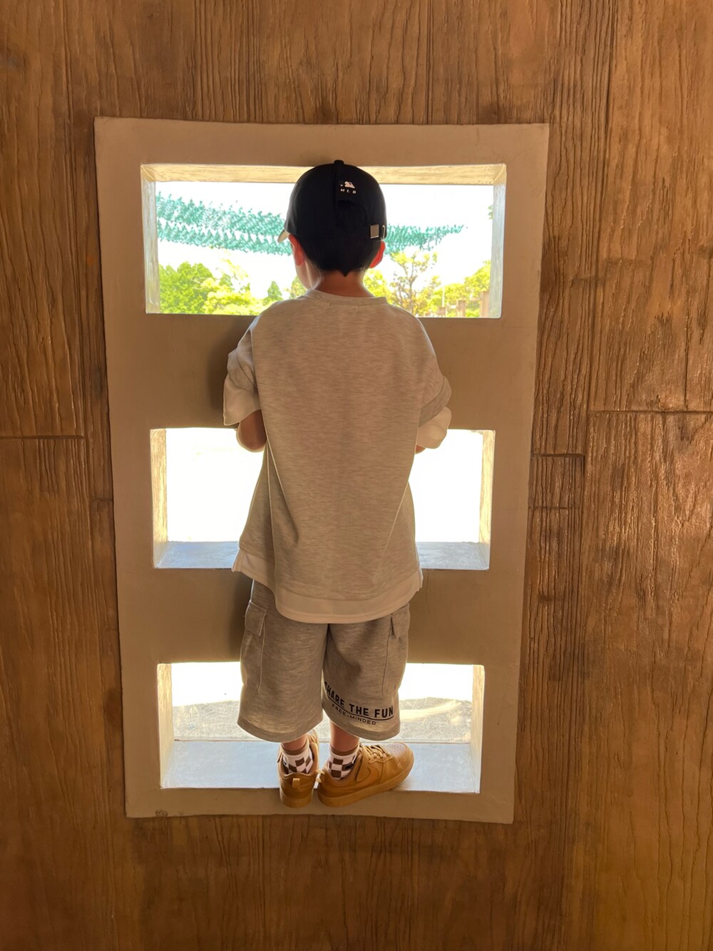 グレー系のトップス、グレー系のカーゴパンツ、ブラック系のキャップを着用したキッズの春コーディネートの2枚目の写真