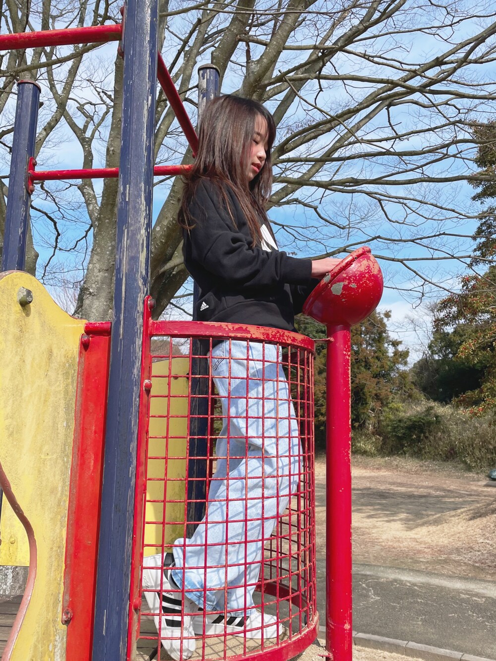 ブラック系のパーカー、ブルー系のデニムパンツ、ホワイト系のスニーカーを着用したキッズの春コーディネートの3枚目の写真