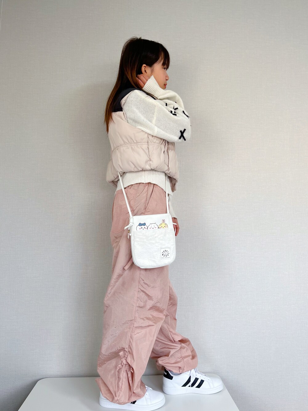 ホワイト系のベスト、ホワイト系のニット/セーター、ピンク系のカーゴパンツを着用したキッズの冬コーディネートの2枚目の写真