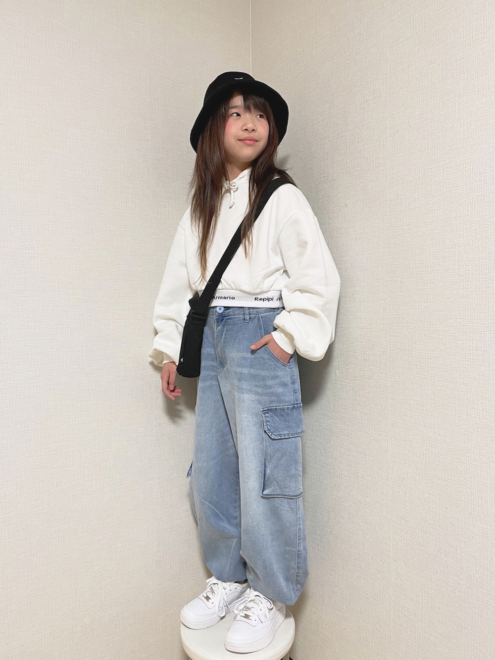 ホワイト系のパーカー、ブルー系のカーゴパンツ、ブラック系のショルダーバッグを着用したキッズの冬コーディネートの2枚目の写真