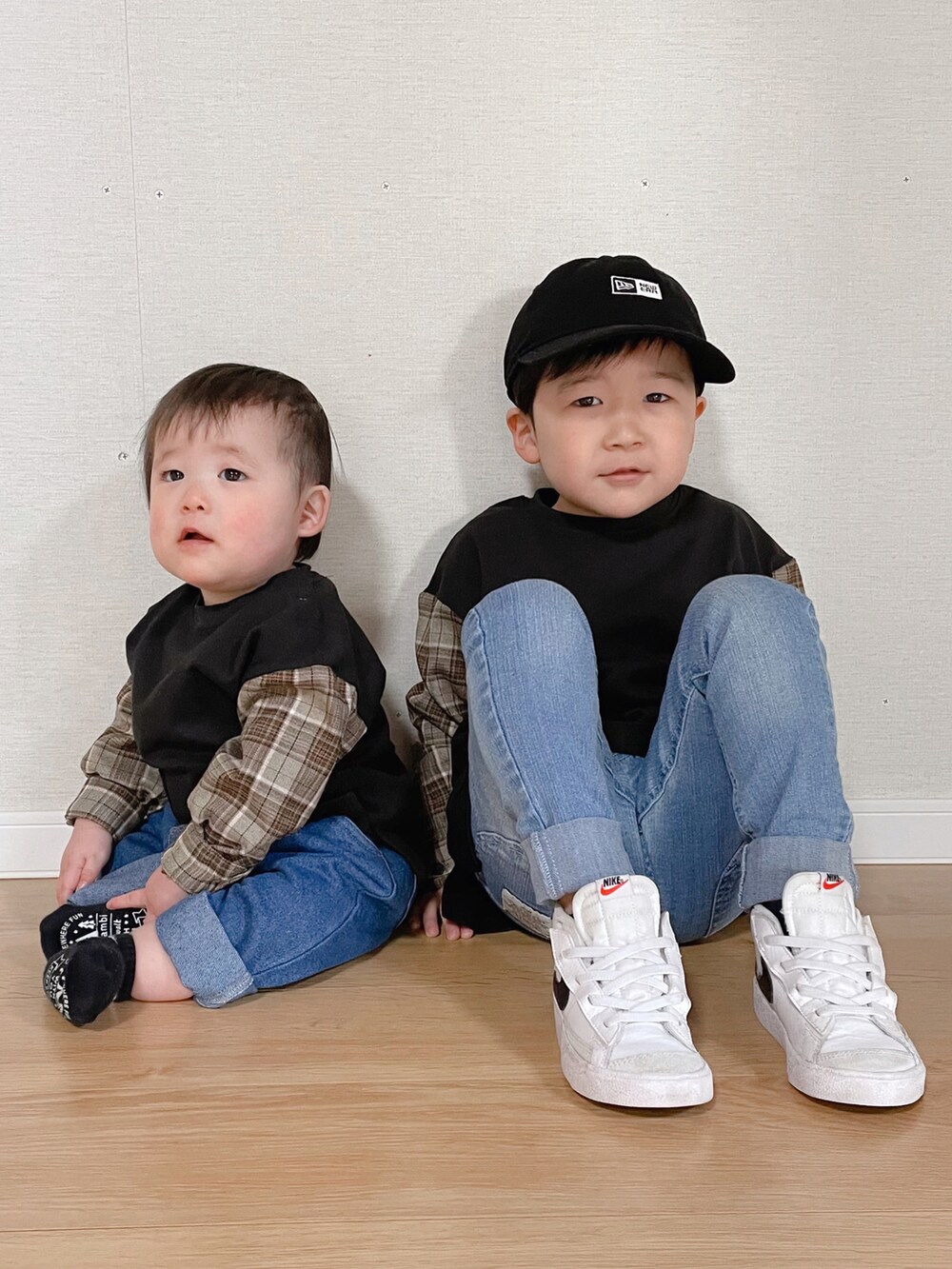 ブラック系のトップス、ホワイト系のスニーカー、ブラック系のキャップを着用したキッズの春コーディネートの2枚目の写真