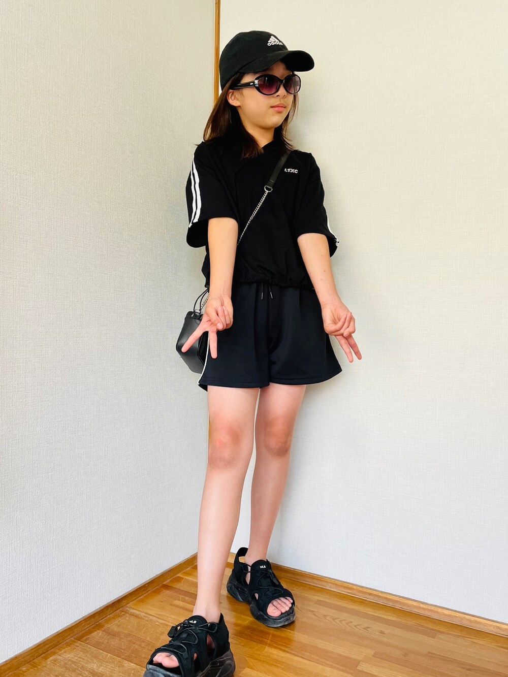 ブラック系のサンダル、ブラック系のパーカー、ブラック系のその他パンツを着用したキッズの夏コーディネートの3枚目の写真