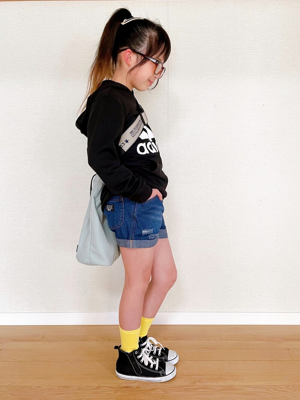 ブラック系のパーカー、ブルー系のデニムパンツ、ブラック系のスニーカーを着用したキッズの春コーディネートの2枚目の写真