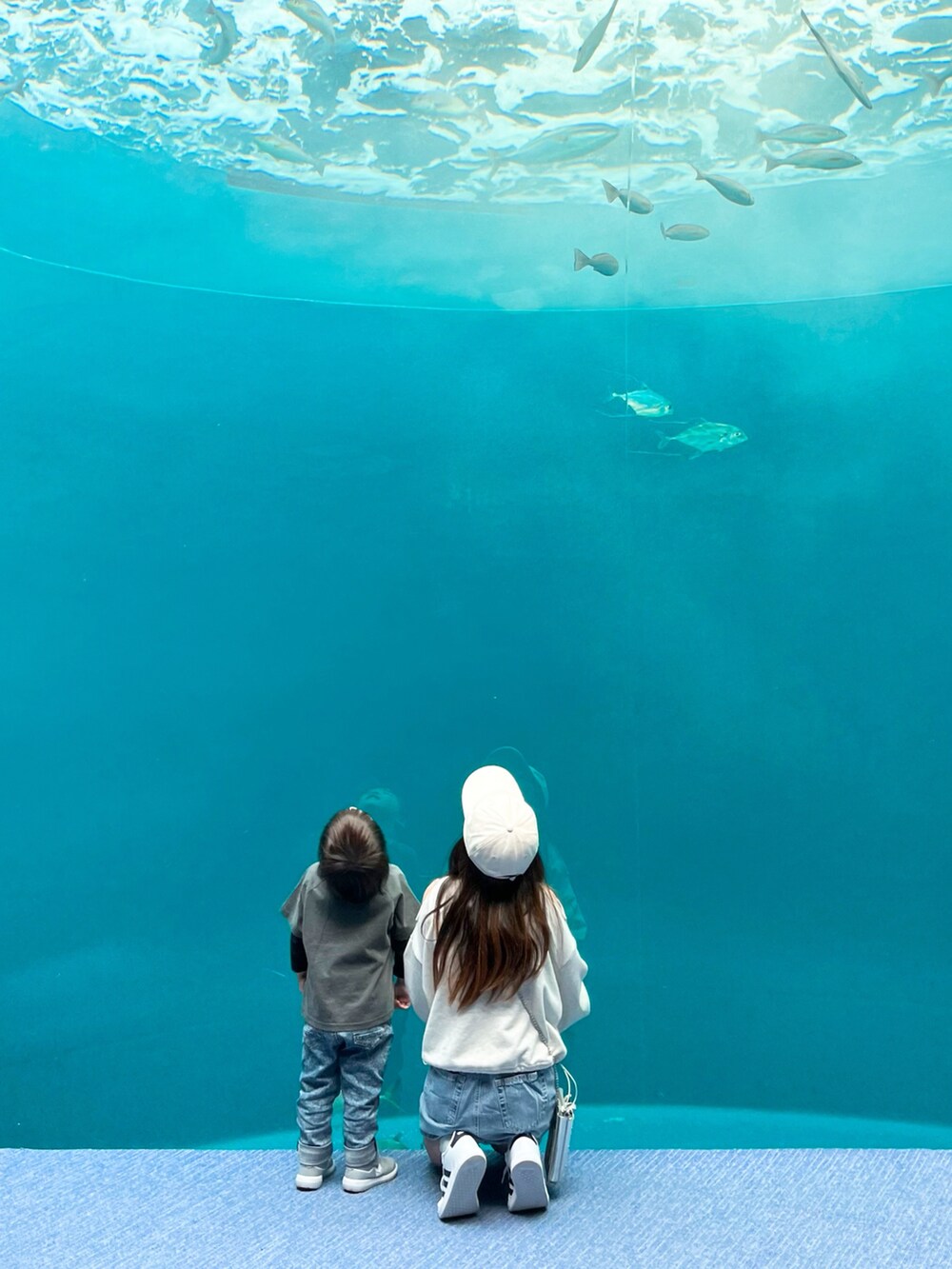 ホワイト系のトップス、ブルー系のスカート、シルバー系のバッグを着用したキッズの春コーディネートの3枚目の写真