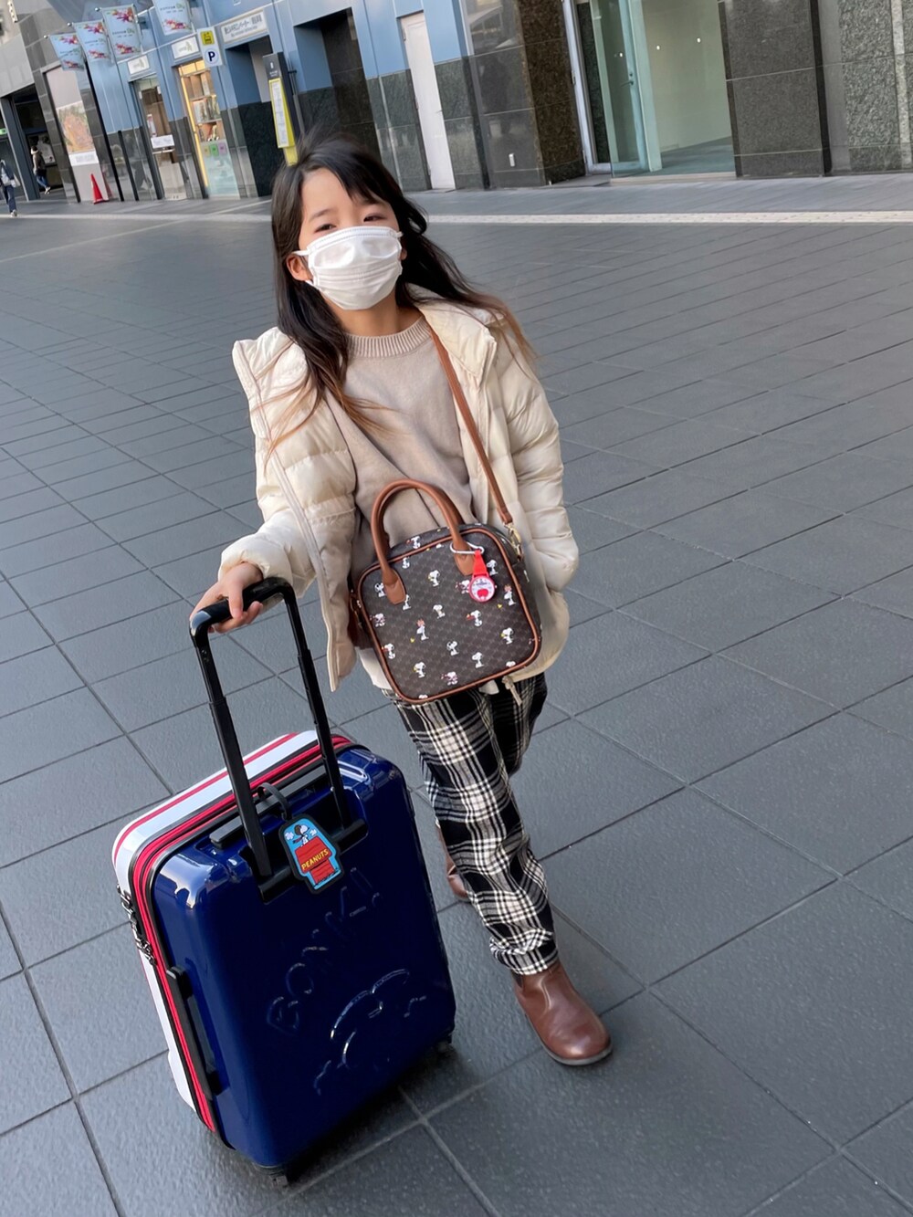 「冬コーデ、あったかコーデ、チェック、チェックパンツ、ブーツ、レイヤードスタイル、ニット、スヌーピー、ダウンジャケット、GLOBAL WORK、カジュアルコーデ、キャリーバッグ、トリコロール」｜「UNIQLOのアイテム（ジャケット/アウター、ホワイト系）」を使った、naaaさん（キッズ・130cm）の冬コーディネートの2枚目の写真