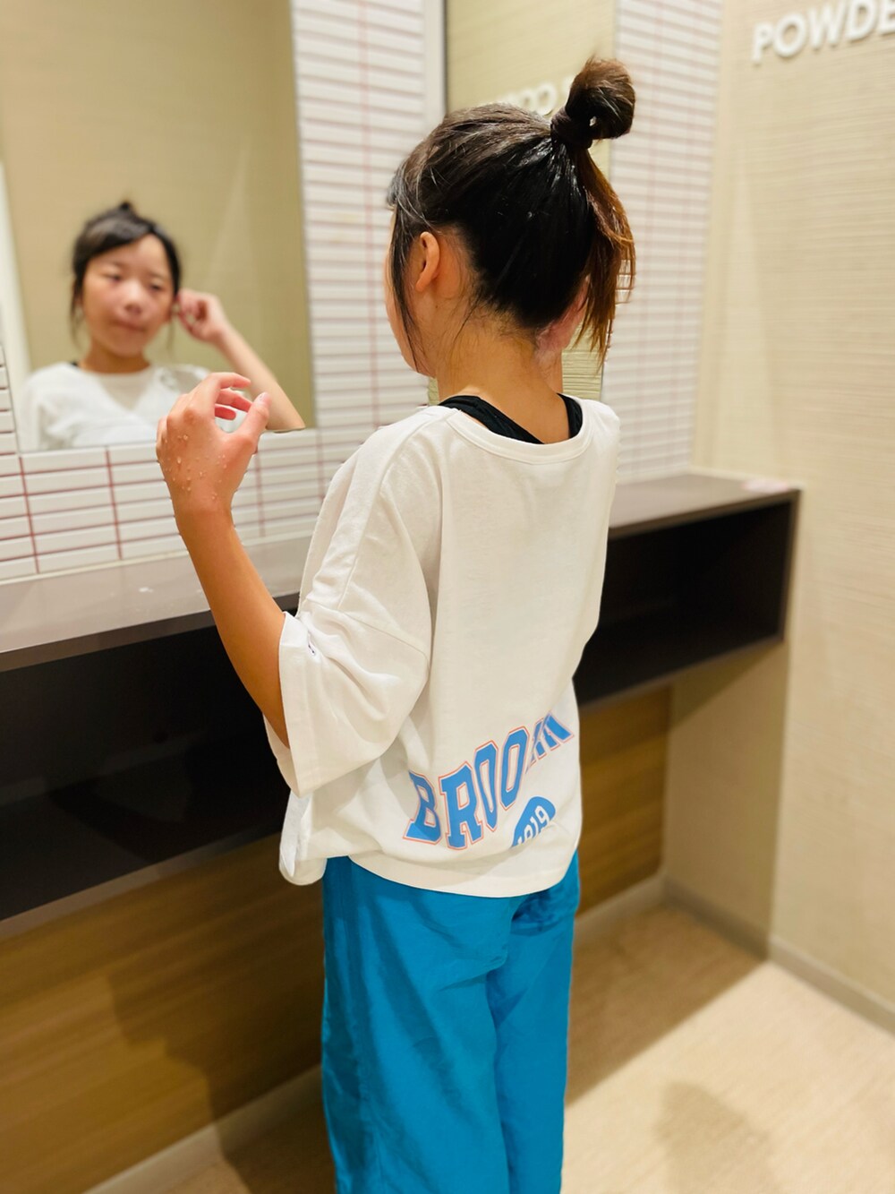 ブルー系のパンツ、ブラック系のサンダル、ホワイト系のTシャツ/カットソーを着用したキッズの夏コーディネートの3枚目の写真