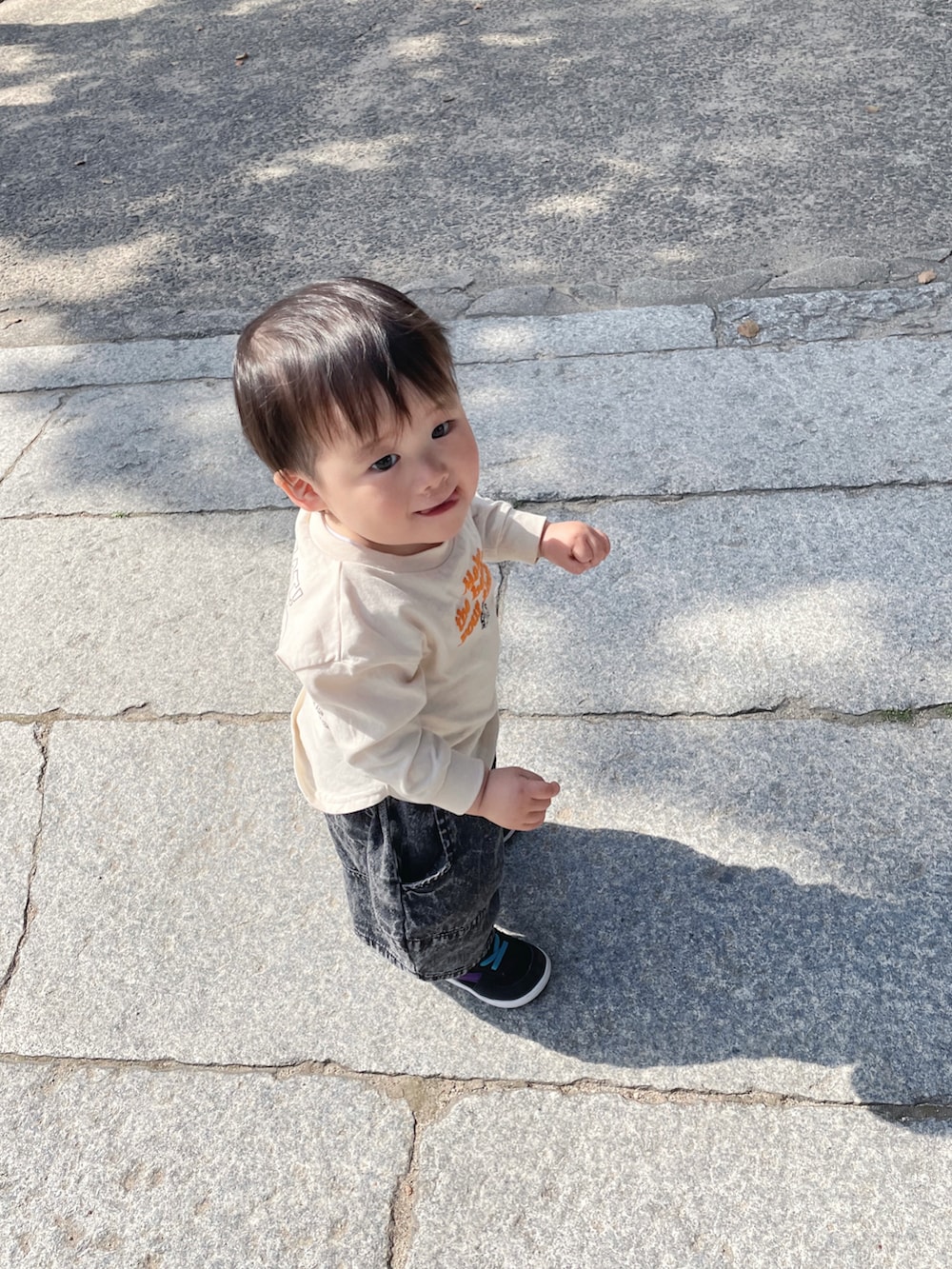 ピンク系のTシャツ/カットソー、ブルー系のパンツ、ホワイト系のスニーカーを着用したキッズの春コーディネートの3枚目の写真