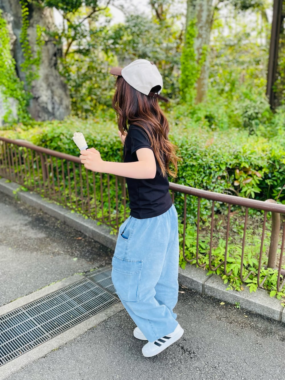 ブラック系のTシャツ/カットソー、ブルー系のカーゴパンツ、ホワイト系のスニーカーを着用したキッズの春コーディネートの2枚目の写真