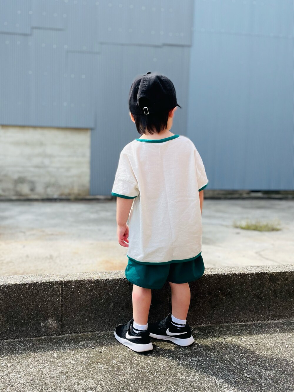 ホワイト系のTシャツ/カットソー、グリーン系のパンツ、ブラック系のキャップを着用したキッズの夏コーディネートの2枚目の写真