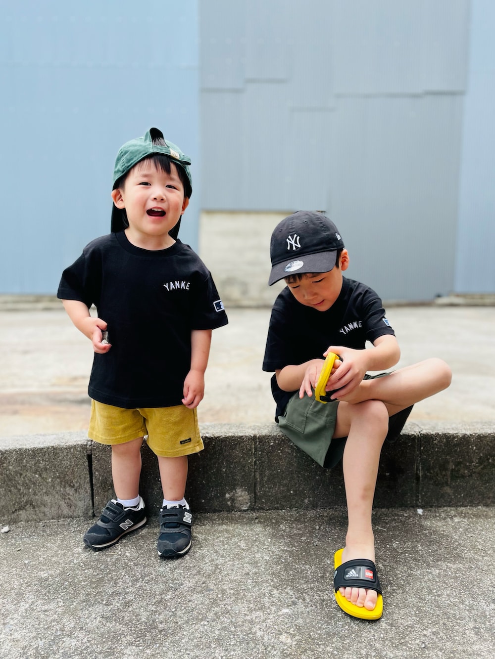 ブラック系のTシャツ/カットソー、ブラック系のサンダル、グリーン系のパンツを着用したキッズの春コーディネートの3枚目の写真