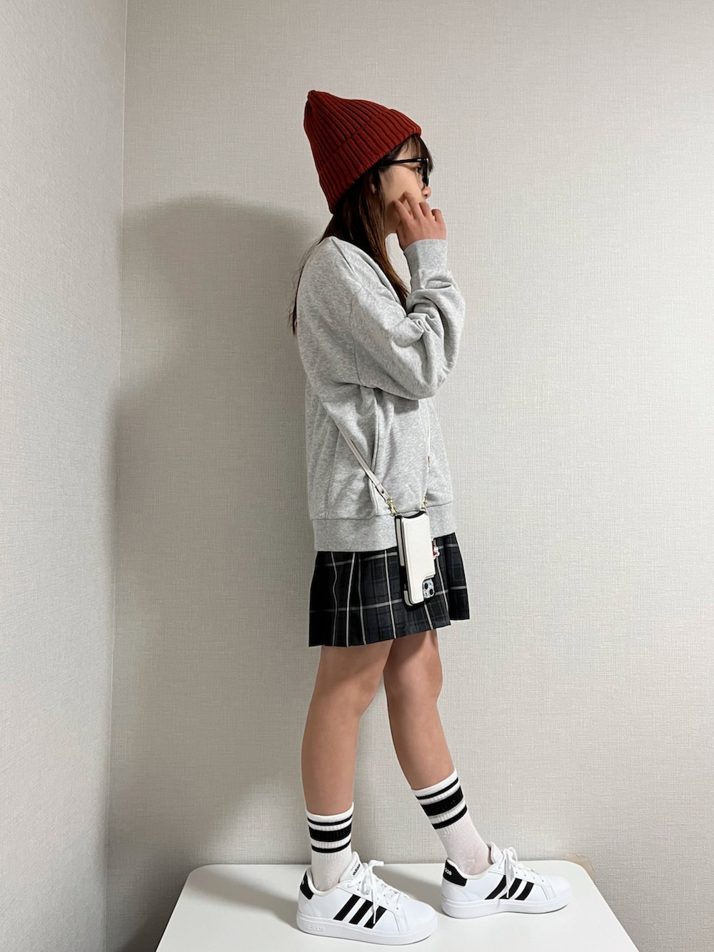 グレー系のスウェット、ホワイト系のスニーカー、レッド系のニットキャップ/ビーニーを着用したキッズの冬コーディネートの2枚目の写真