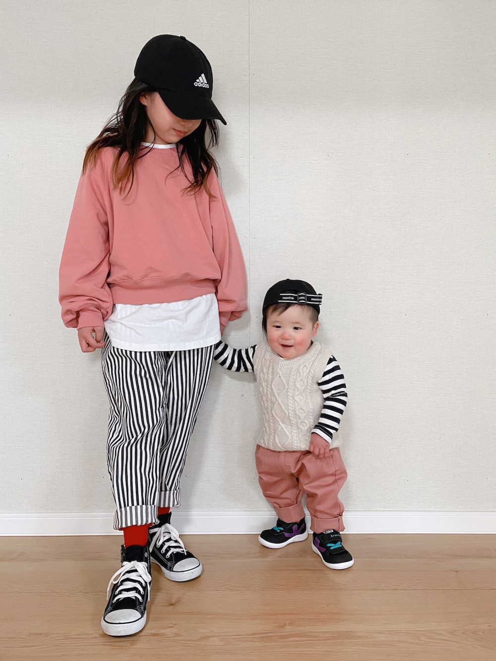 ピンク系のスウェット、ブルー系のその他パンツ、ブラック系のスニーカーを着用したキッズの春コーディネートの2枚目の写真