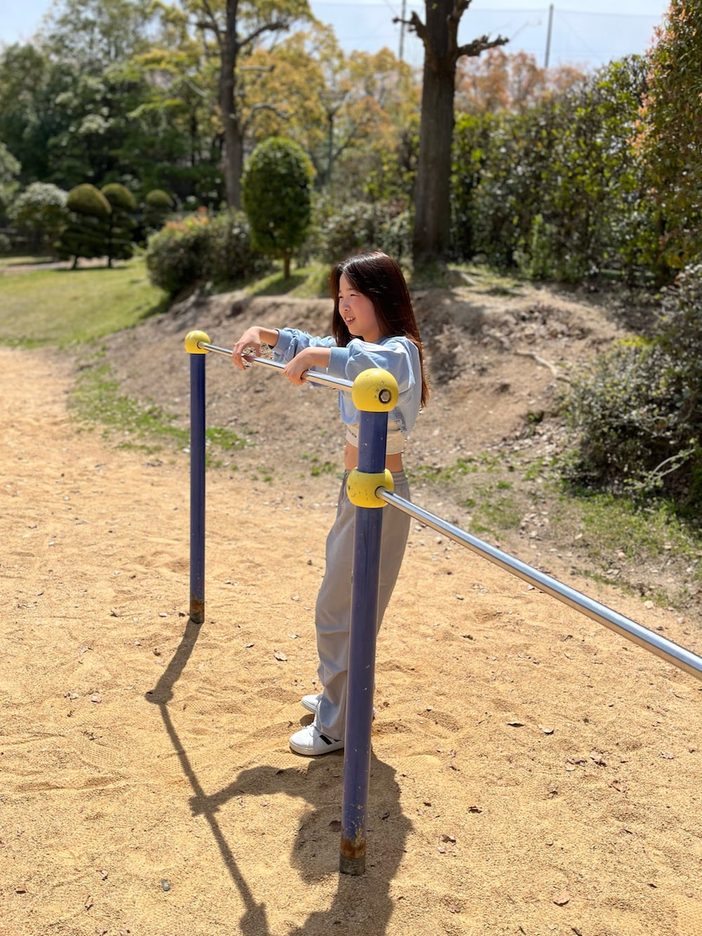 グレー系のパンツ、ブルー系のワンピースを着用したキッズの春コーディネートの2枚目の写真