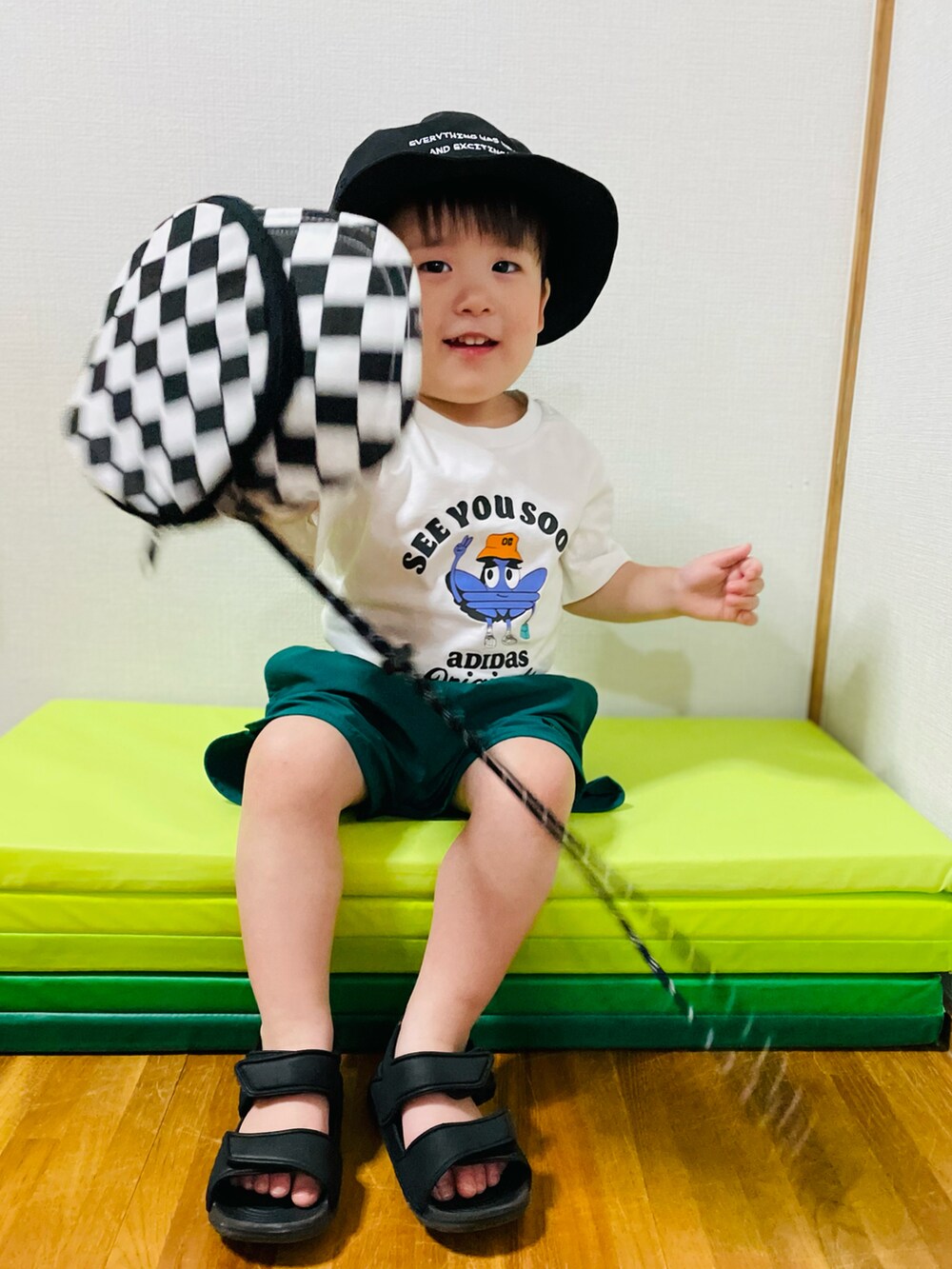 ホワイト系のジャージ、グリーン系のパンツを着用したキッズの夏コーディネートの2枚目の写真