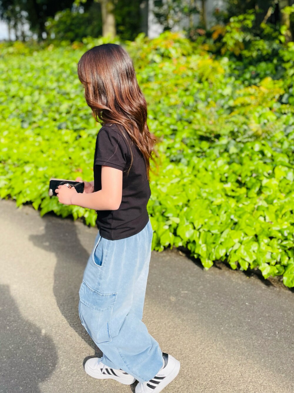 ブラック系のTシャツ/カットソー、ブルー系のカーゴパンツ、ホワイト系のスニーカーを着用したキッズの春コーディネートの4枚目の写真