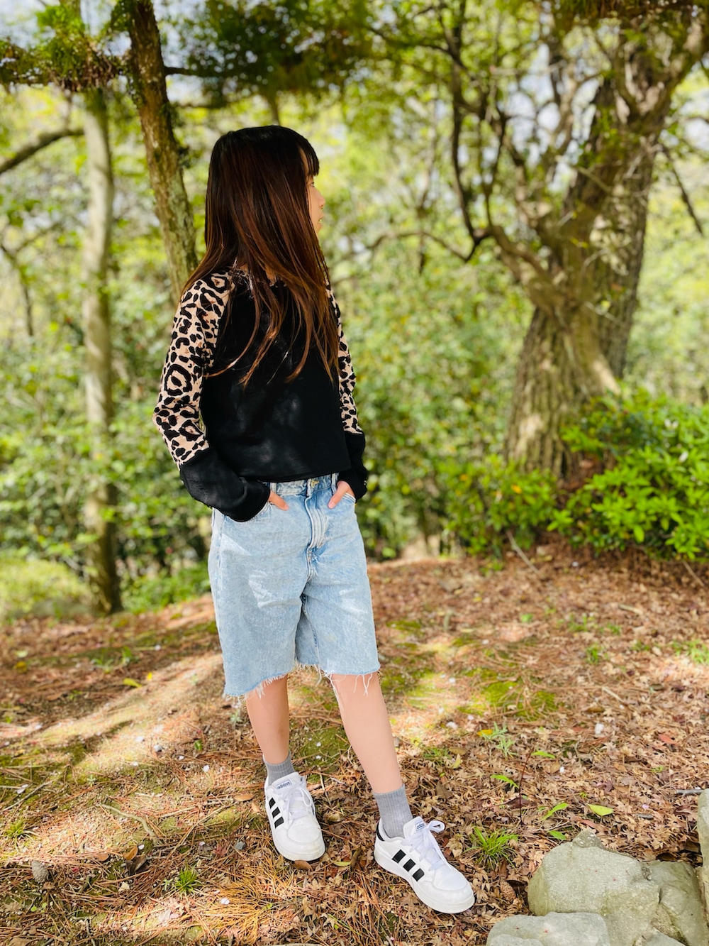 ブラック系のトップス、ブルー系のパンツ、ホワイト系のスニーカーを着用したキッズの春コーディネートの4枚目の写真