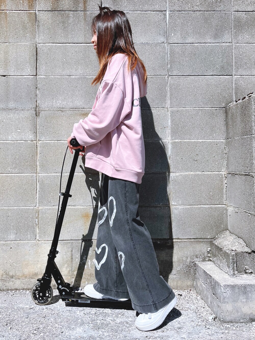 ピンク系のパーカー、グレー系のパンツ、ホワイト系のスニーカーを着用したキッズの春コーディネートの2枚目の写真