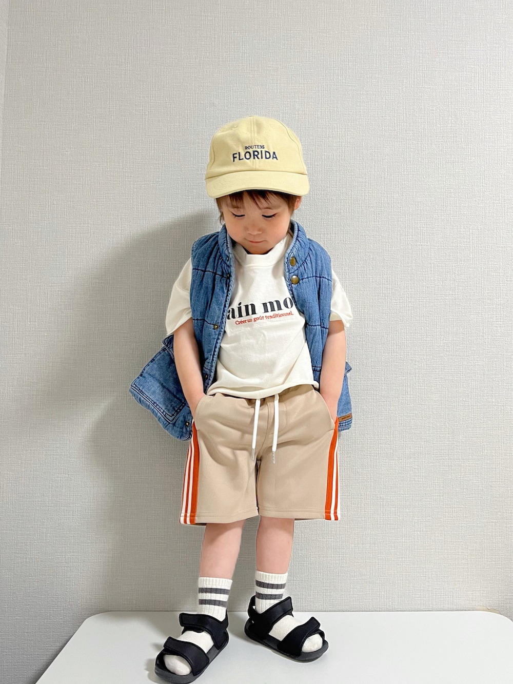 ホワイト系のTシャツ/カットソー、ベージュ系のパンツ、ブラウン系のキャップを着用したキッズの冬コーディネートの3枚目の写真