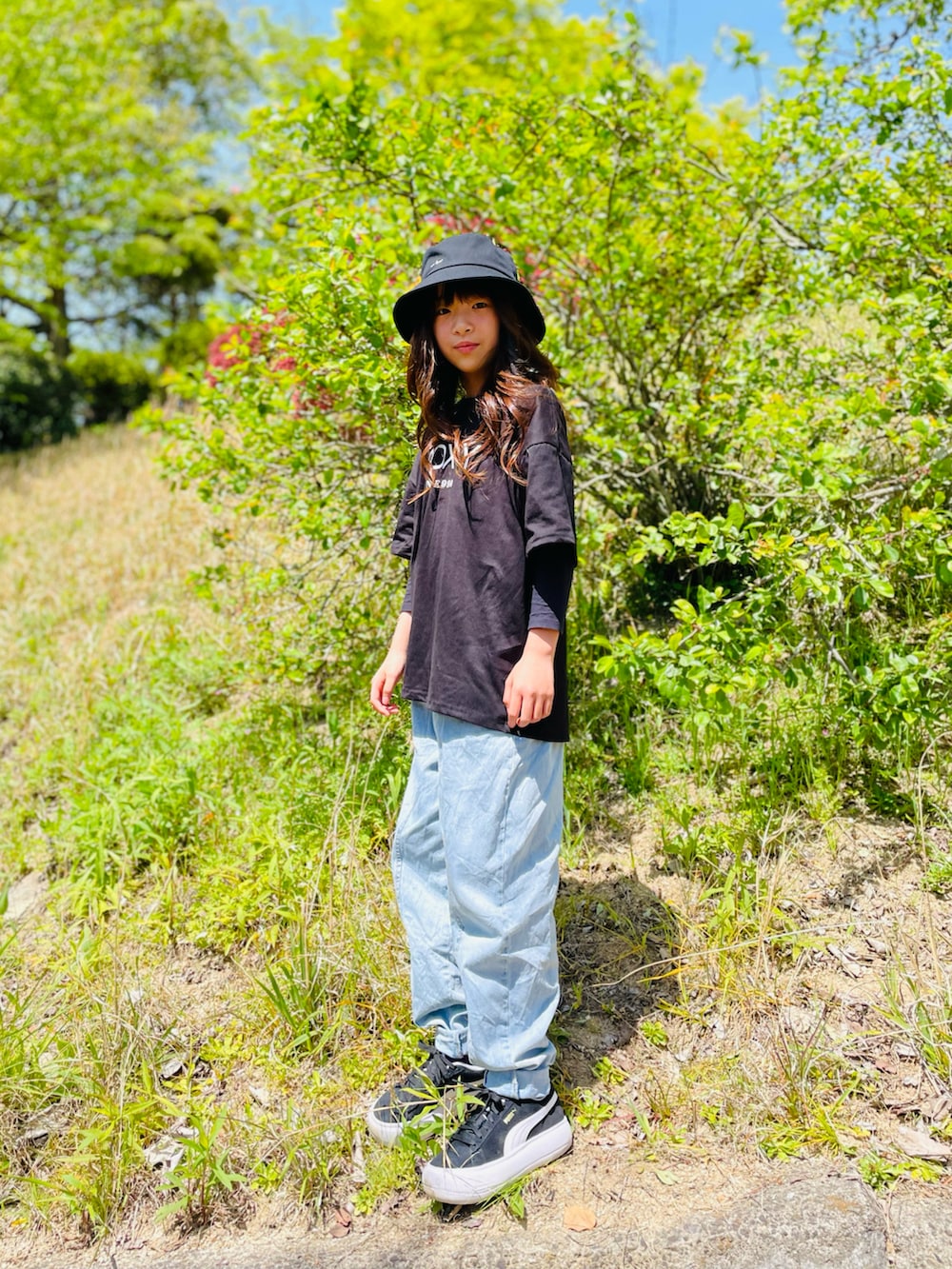 ブルー系のパンツ、ブラック系のスニーカー、ブラック系のTシャツ/カットソーを着用したキッズの春コーディネートの3枚目の写真