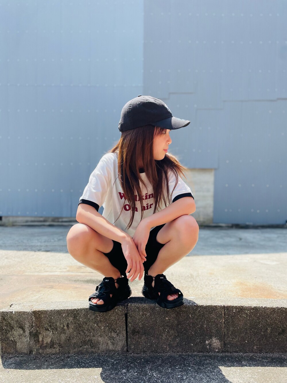 ホワイト系のTシャツ/カットソー、ブラック系のサンダル、ブラック系のキャップを着用したキッズの夏コーディネートの3枚目の写真