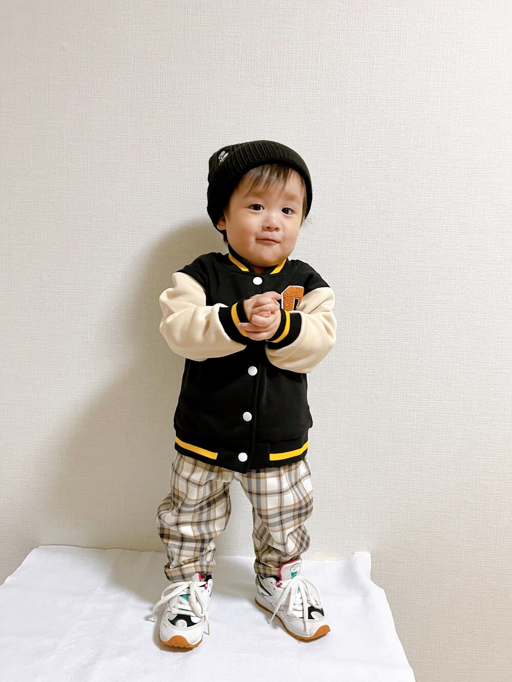 ブラック系のブルゾン、ホワイト系のスニーカー、ホワイト系のその他パンツを着用したキッズの秋コーディネートの2枚目の写真