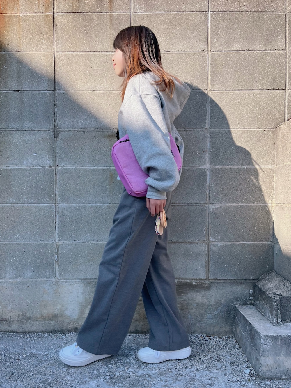 グレー系のパンツ、パープル系のバックパック/リュック、ホワイト系のスニーカーを着用したキッズの冬コーディネートの2枚目の写真