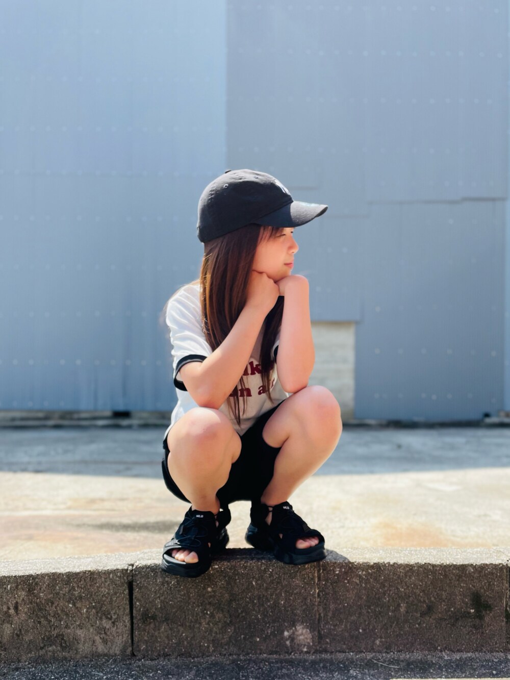 ホワイト系のTシャツ/カットソー、ブラック系のサンダル、ブラック系のキャップを着用したキッズの夏コーディネートの2枚目の写真