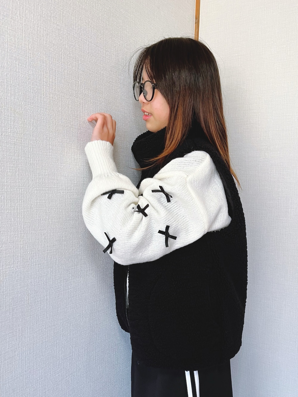 ホワイト系のニット/セーター、ブラック系のスカート、ブラック系のベストを着用したキッズの冬コーディネートの4枚目の写真