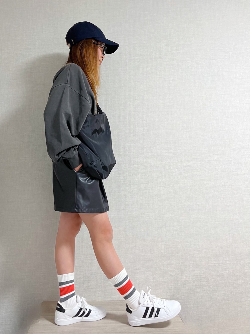 ブラック系のショルダーバッグ、グレー系のトップス、ブラック系のパンツを着用したキッズの冬コーディネートの2枚目の写真