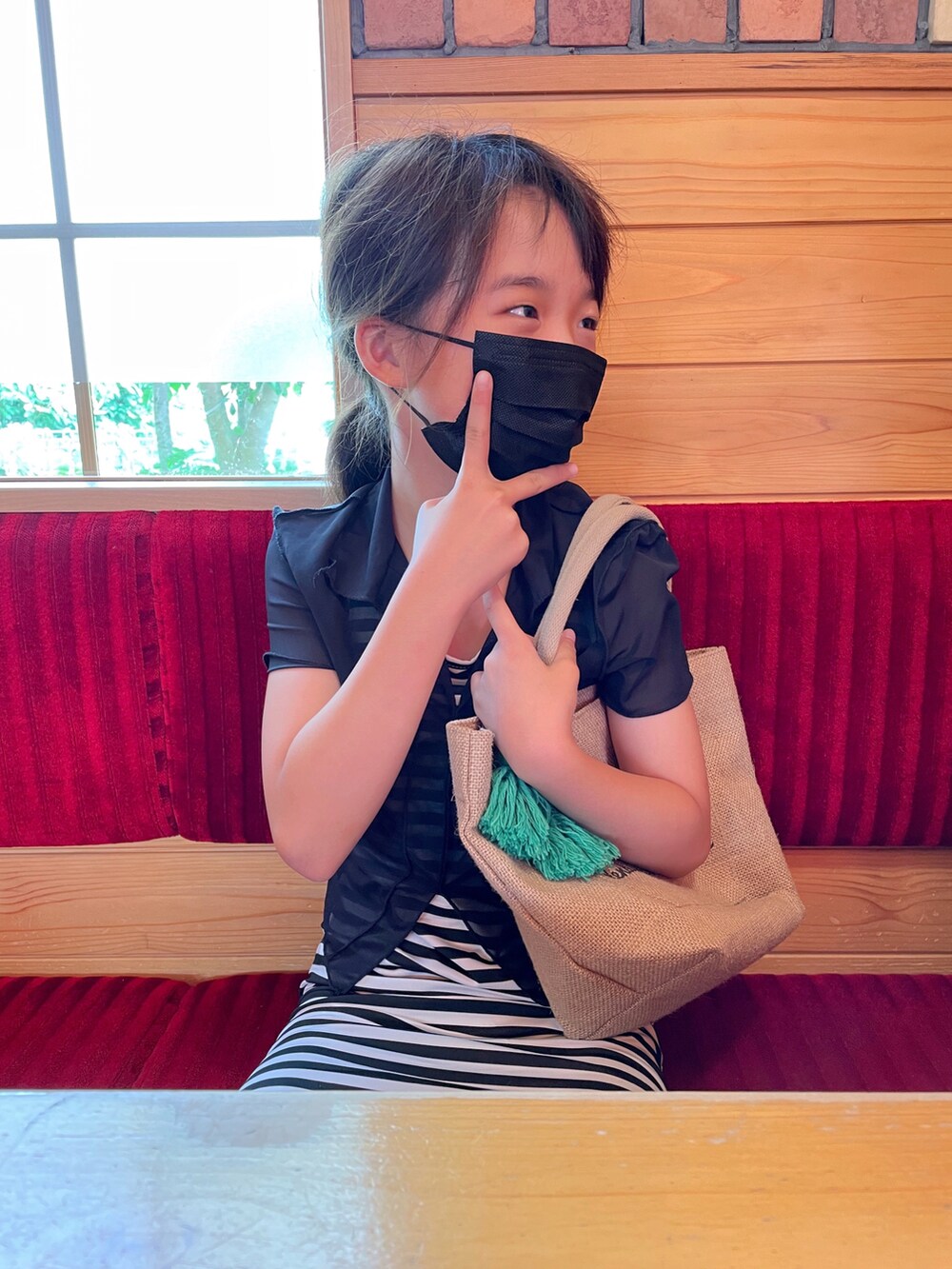 ブラック系のワンピース/ドレス、ブラック系のトップス、グリーン系のトートバッグを着用したキッズの夏コーディネートの2枚目の写真