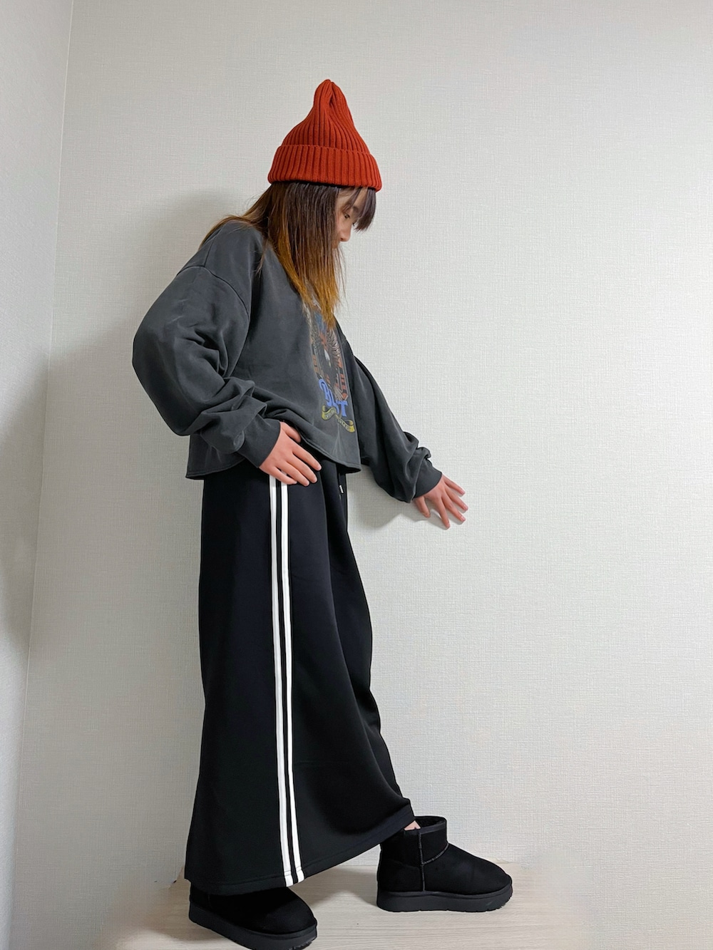 グレー系のトップス、ブラック系のスカート、ブラック系のブーツを着用したキッズの冬コーディネートの2枚目の写真