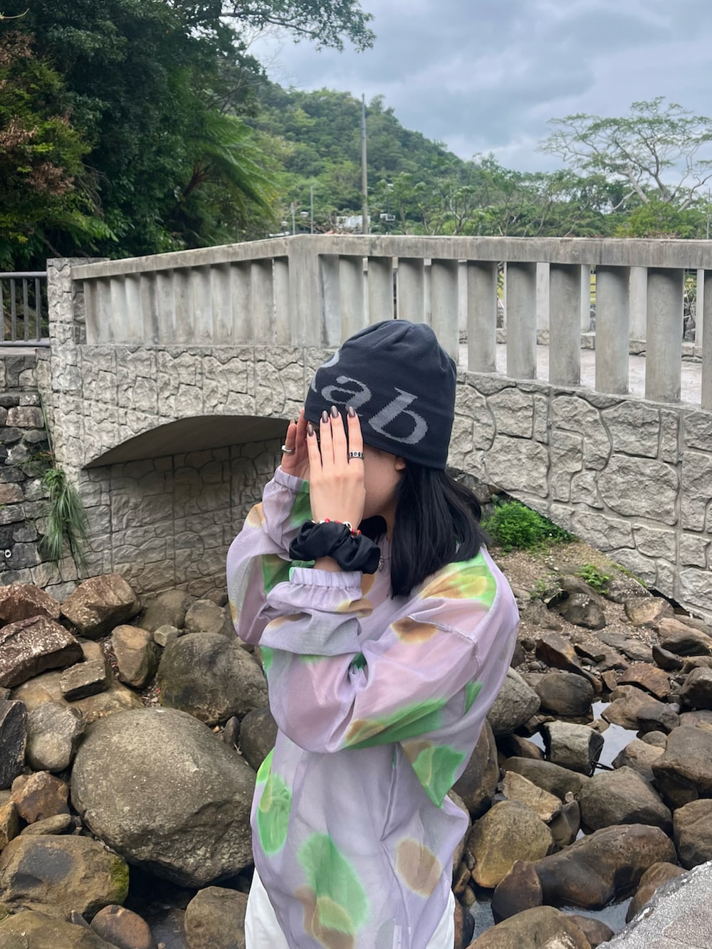 グレー系のスニーカー、パープル系のトップス、ブラック系の帽子を着用したレディースの冬コーディネートの2枚目の写真