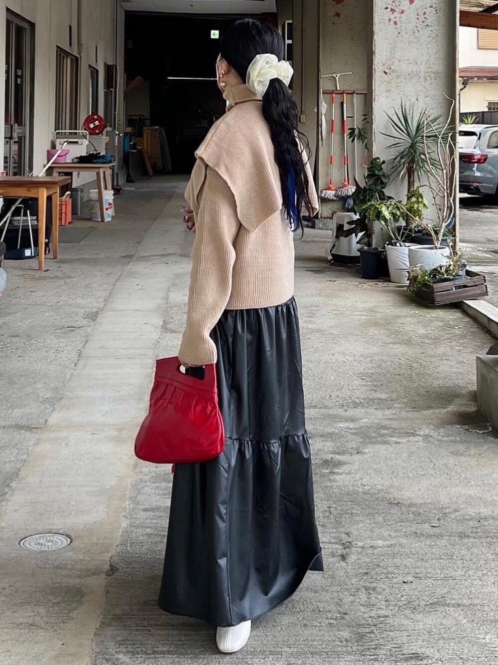 ベージュ系のニット/セーター、オレンジ系のマフラーを着用したレディースの冬コーディネートの2枚目の写真