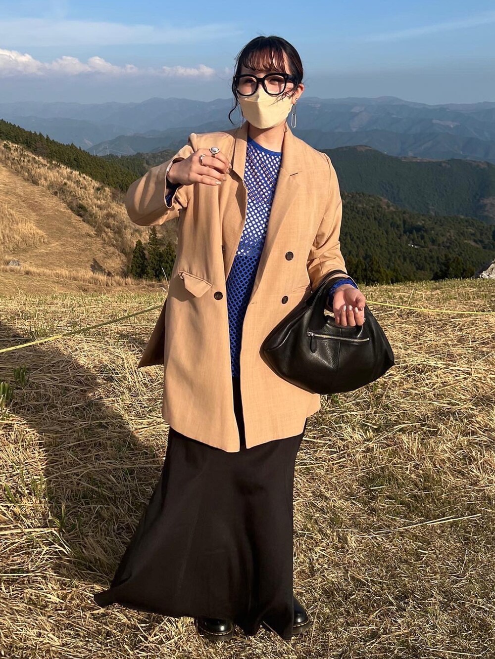 ベージュ系のテーラードジャケット、ブラック系のスカートを着用したレディースの春コーディネートの2枚目の写真