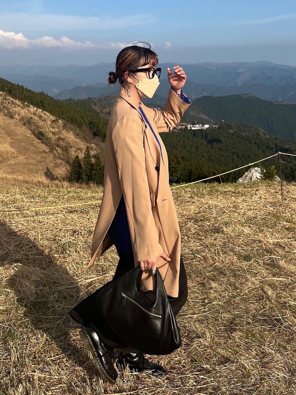 ベージュ系のテーラードジャケット、ブラック系のスカートを着用したレディースの春コーディネートの3枚目の写真