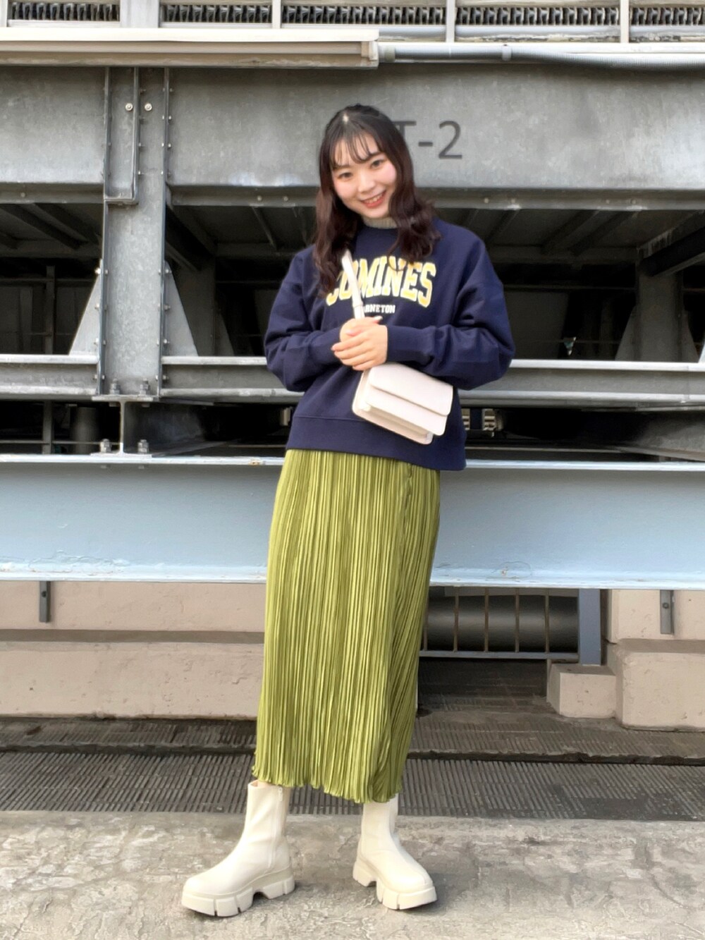 ブルー系のスウェット、ホワイト系のブーツ、グリーン系のスカートを着用したレディースの冬コーディネートの2枚目の写真