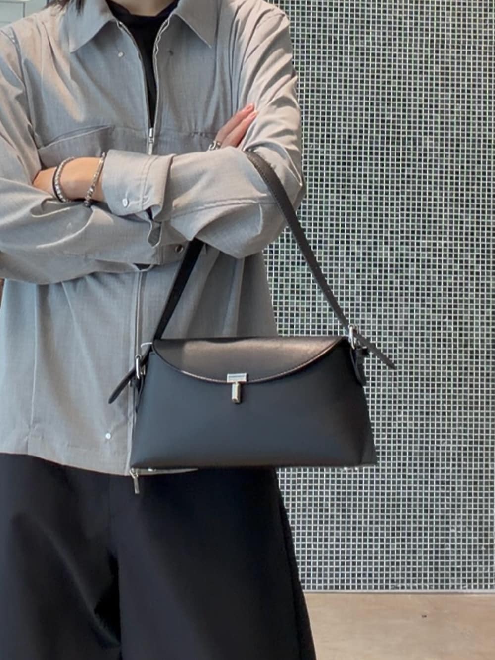 グレー系のシャツ/ブラウス、ブラック系のスラックス、ブラック系のハンドバッグを着用したメンズの春コーディネートの2枚目の写真