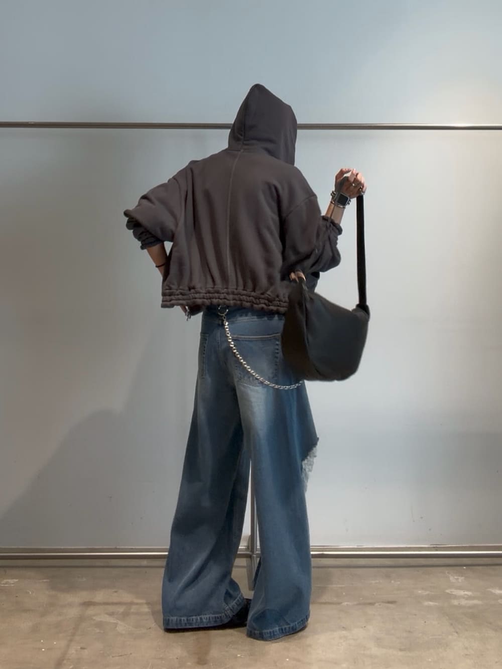 ブルー系のデニムパンツ、グレー系のパーカー、ブラック系のベルトを着用したメンズの夏コーディネートの4枚目の写真